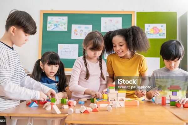 Portrait of asian caucasian little children playing blocks in classroom. Learning by playing education group study concept. International pupils doing activities brain training in primary school.